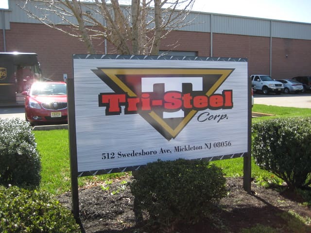 Outdoor business sign for Tri-Steel Corp with company address displayed.
